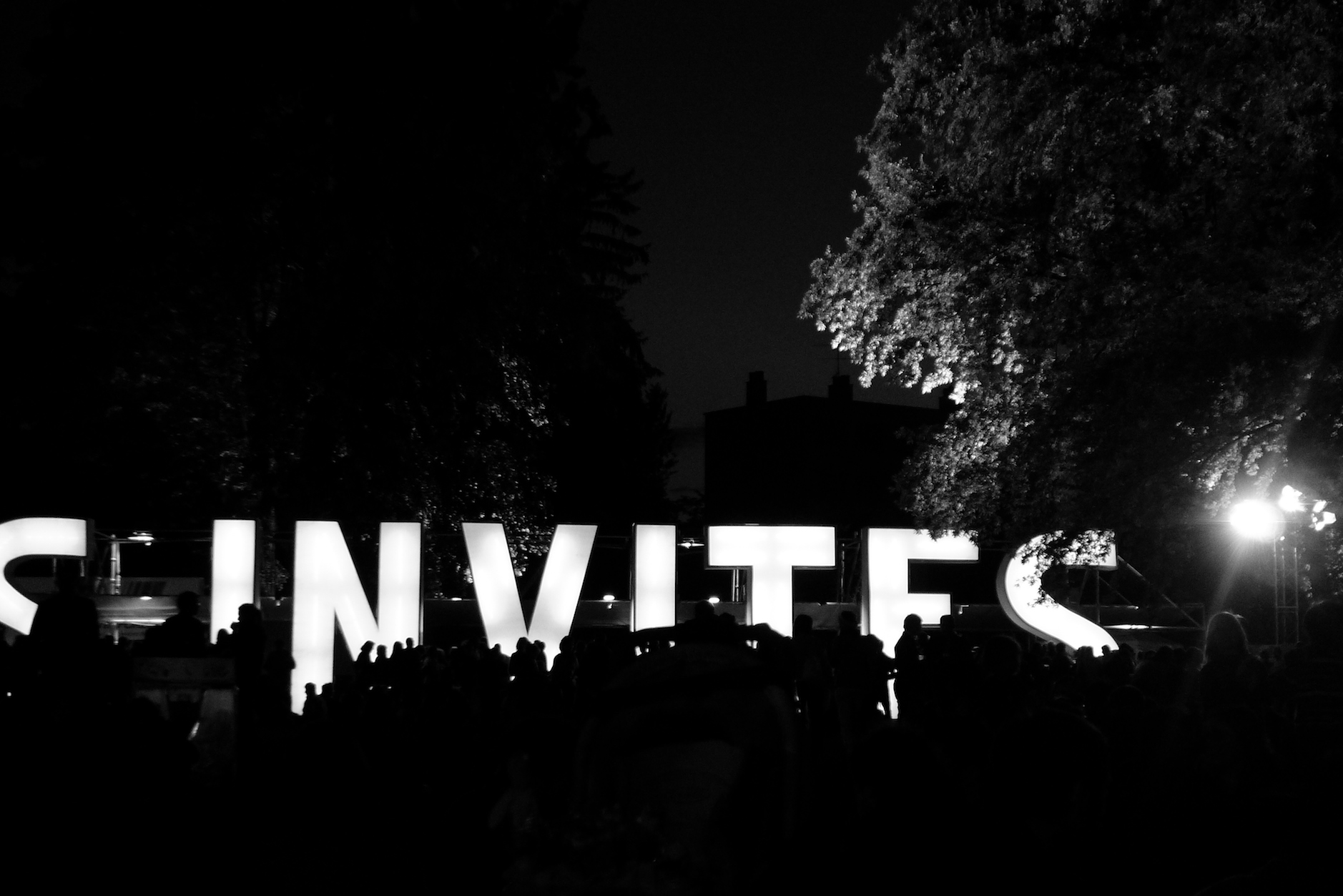 Soirée dans un parc la nuit, noir et blanc, lettres INVITES géantes lumineuses, les Invites de Villeurbanne
