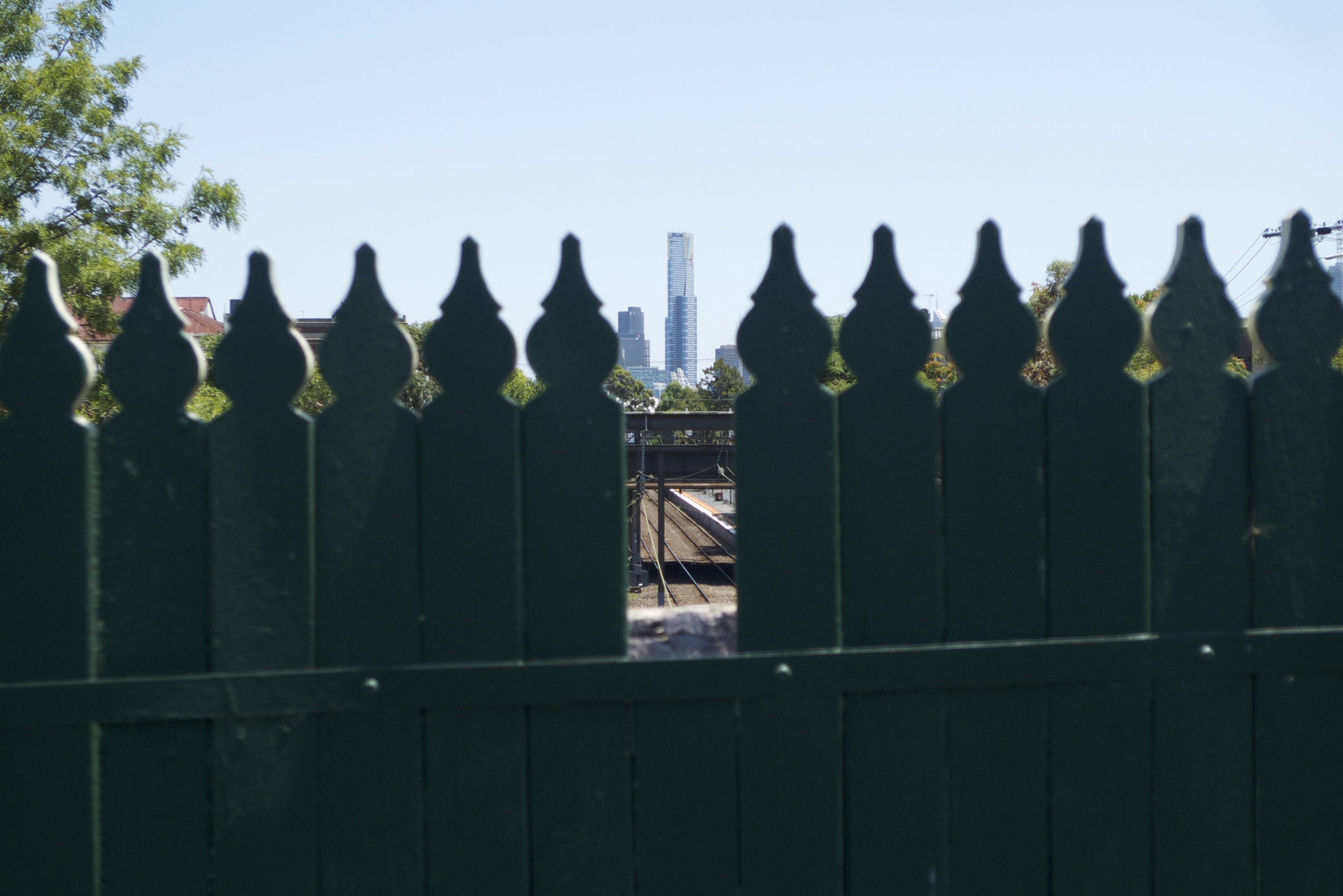La skyline de Melbourne : la tour Eureka vue à travers un trou dans une palissade